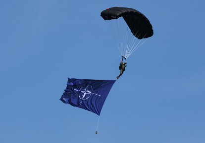 Парашутист з прапором НАТО під час військового параду з нагоди Дня Війська Польського, 15 серпня 2026 року у Варшаві (Польща)