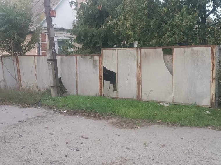Поврежденный обстрелом забор