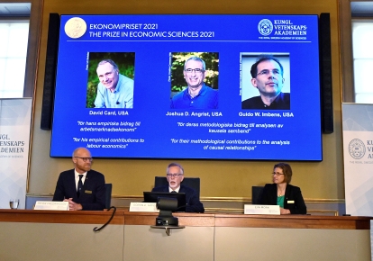 Нобелевские лауреаты по экономике Дэвид Кард, Джошуа Ангрист и Гвидо Имбенс (на экране)