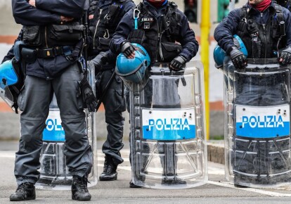 Офицеры полиции по борьбе с массовыми беспорядками стоят возле тюрьмы Сан-Витторе в Милане во время акции протеста заключенных,  в одной из карантинных красных зон Италии 9 марта 2020 г.