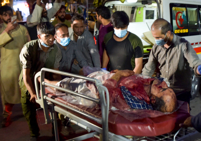 Волонтеры и медицинский персонал перевозят раненного после двух мощных взрывов, за пределами аэропорта в Кабуле 26 августа 2021 г.