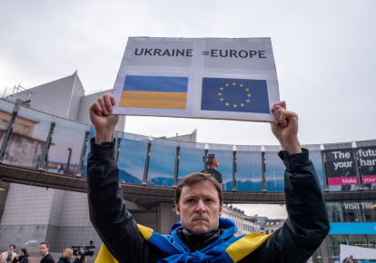 Активист держит транспарант в поддержку украинского народа у здания Европейского парламента 1 марта 2022 г. в Брюсселе, Бельгия