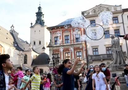 Діти - туристи з Близького Сходу, грають з мильними бульбашками у Львові