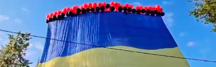 В небе Донецка летает огромный украинский флаг на красно-черных шарах