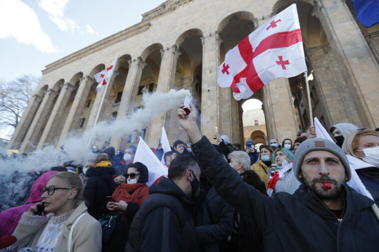 Люди принимают участие в митинге оппозиции в поддержку лидера грузинской оппозиции Ники Мелии перед зданием парламента в Тбилиси